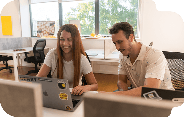 graduados del bootcamp de Henry mientras trabajan en equipo en una oficina de tecnología